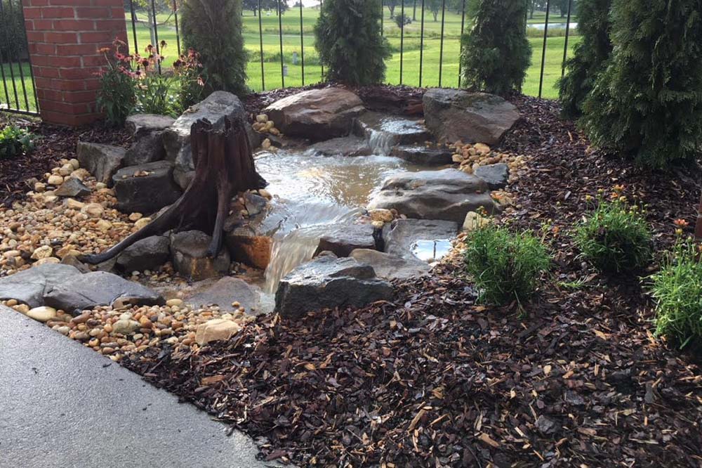 A clean JVI pondless waterfall feature with stacked stone.
