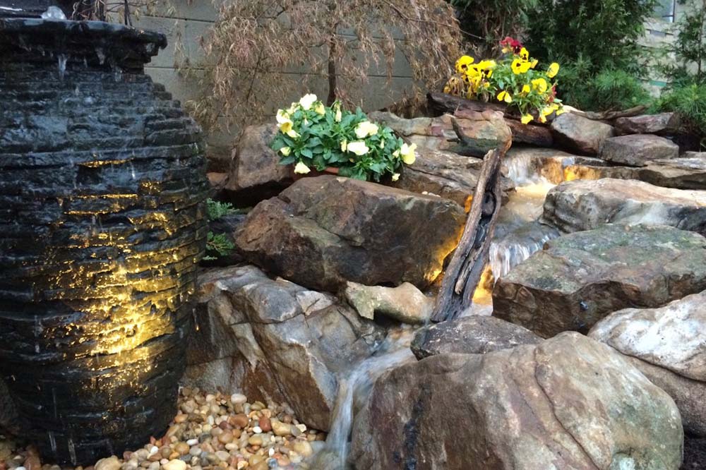 A lit vase fountain next to a JVI stream feature.
