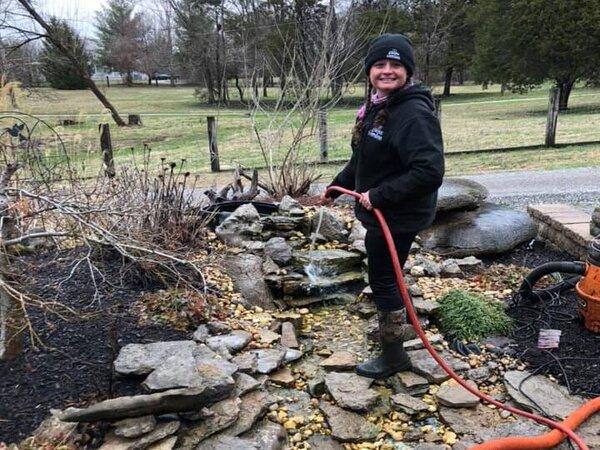 Jamie from the JVI crew cleaning out a water feature.