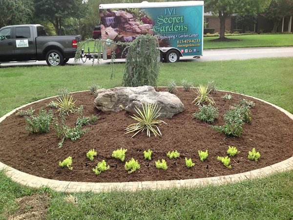 Finished JVI Secret Gardens landscape island with the company truck behind it