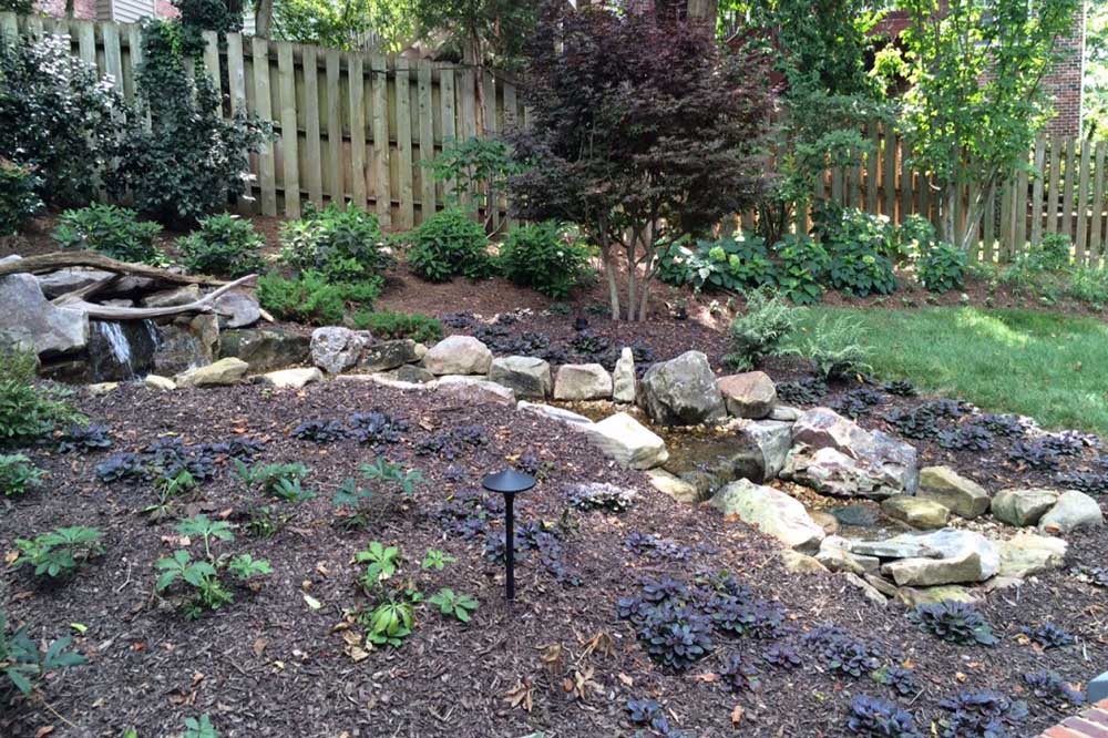 A stream feeding a pondless basin, leaves and debris cleared